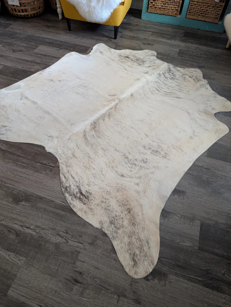 A large cowhide rug es24 in natural white and gray with a soft textured surface, perfect for beautiful rugs collection