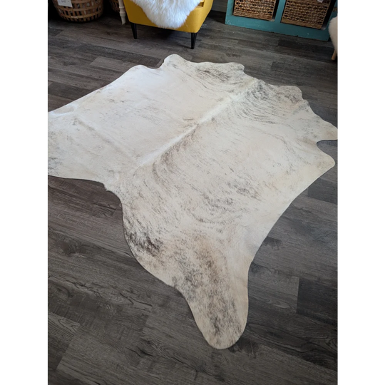 A large cowhide rug es24 in natural white and gray with a soft textured surface, perfect for beautiful rugs collection
