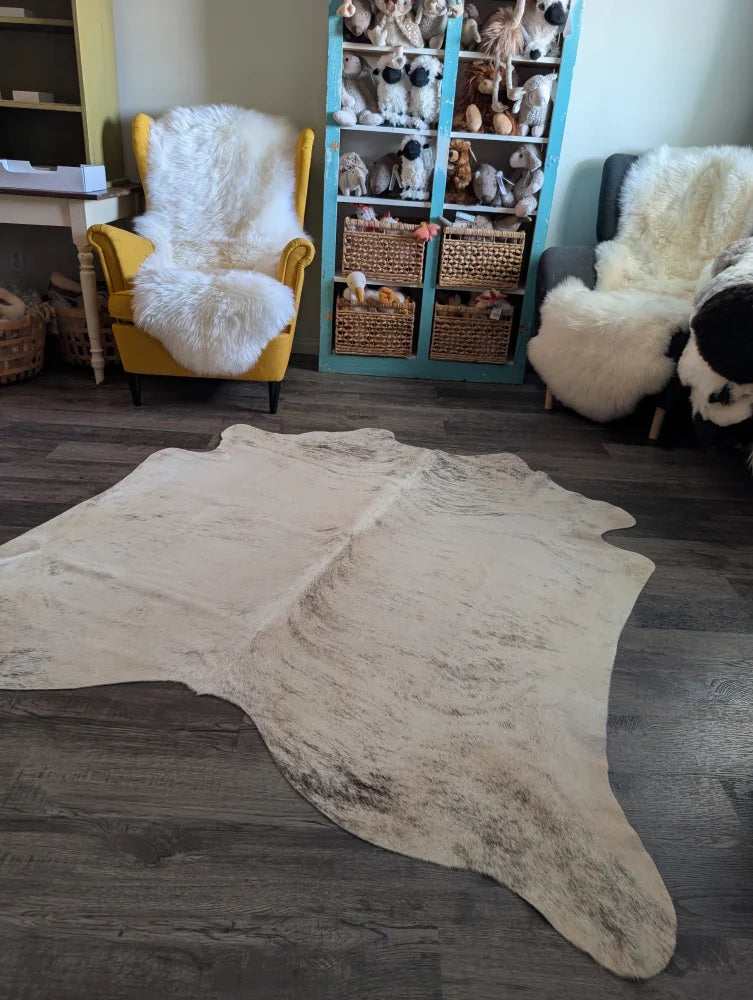 Cream-colored large cowhide rug es24 with natural edges and subtle dark speckling perfect for beautiful rugs