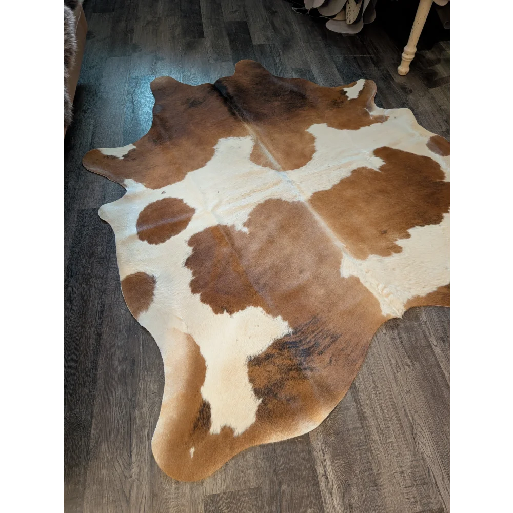 Large cowhide rug featuring brown and white natural irregular patches perfect for beautiful rugs in home decor