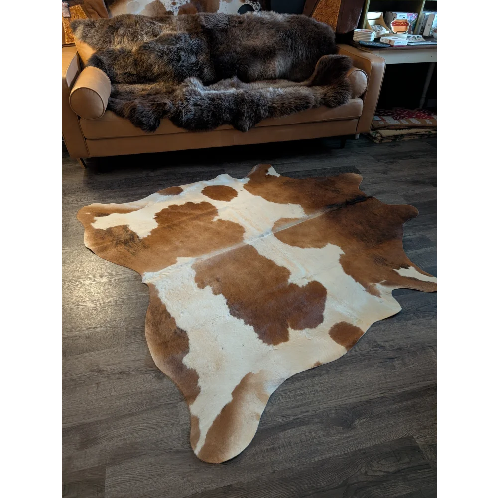 Large cowhide rug with brown and white natural irregular patches perfect for beautiful rugs in living spaces