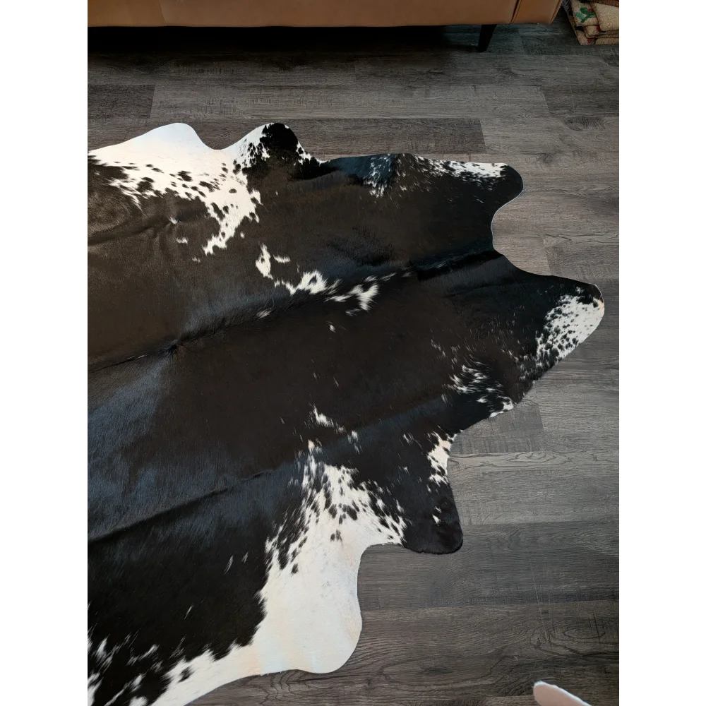 Large black and white cowhide rug with natural irregular edges perfect for beautiful rugs and home decor