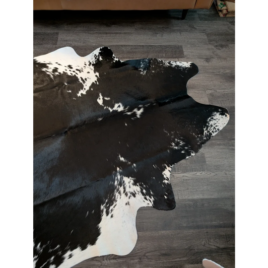 Large black and white cowhide rug with natural irregular edges perfect for beautiful rugs and home decor