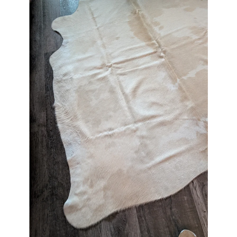 Cream-colored large cowhide rug with natural fur texture and irregular edges beautiful rugs for any room