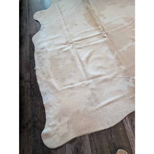 Cream-colored large cowhide rug with natural fur texture and irregular edges beautiful rugs for any room