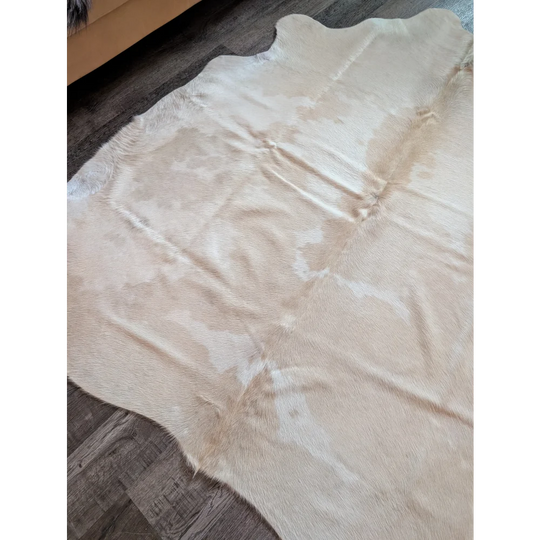 A large natural-toned cowhide rug es703 with soft texture and irregular edges perfect for beautiful rugs lovers