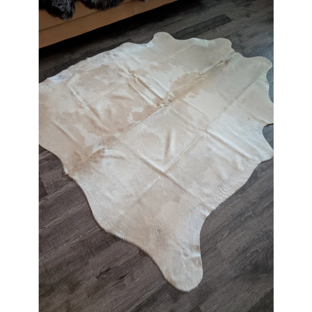 A large natural white and beige cowhide rug with a soft textured surface perfect for beautiful rugs lovers