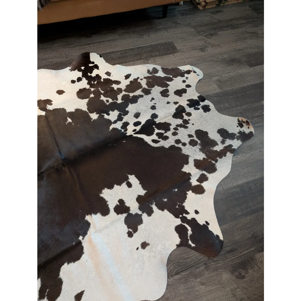 Large cowhide rug es706 with a black and white spotted pattern and unique irregular edges perfect for home decor