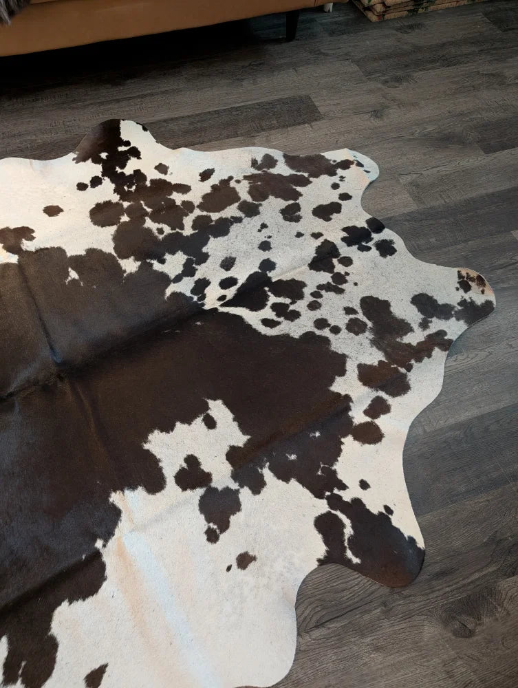 Large cowhide rug es706 with a black and white spotted pattern and unique irregular edges perfect for home decor