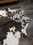 Large cowhide rug es706 with a black and white spotted pattern and unique irregular edges perfect for home decor
