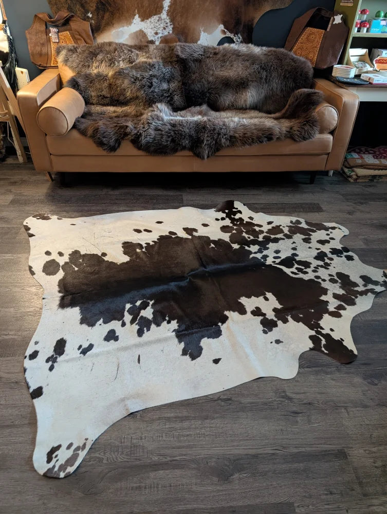 Large cowhide rug es#706 with unique black and white spotted pattern measuring 78 by 68 inches