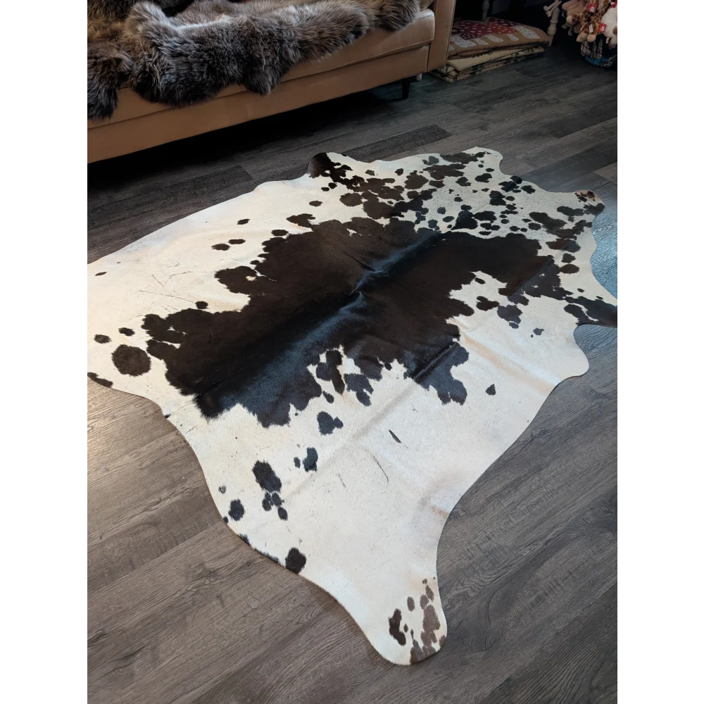 Large cowhide rug es706 with a striking black and white spotted pattern and unique organic shape perfect for any room
