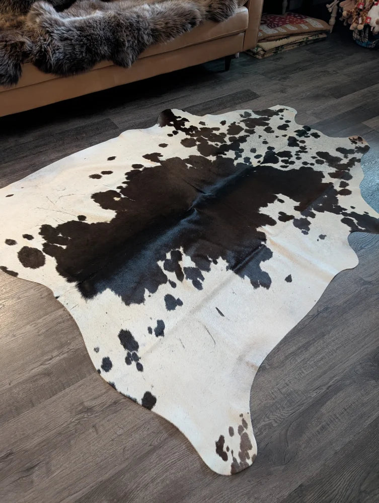 Large cowhide rug es706 with a striking black and white spotted pattern and unique organic shape perfect for any room