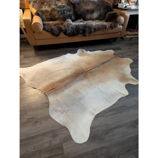 A large cowhide rug es708 in natural beige and cream tones with a soft textured surface perfect for beautiful rugs