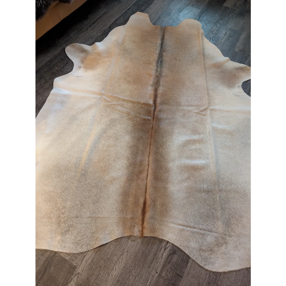 Natural tan large cowhide rug with soft textured surface and subtle color variations perfect for beautiful rugs