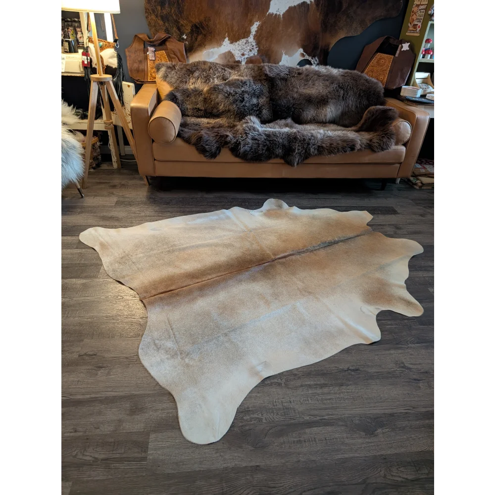 Large natural-toned cowhide rug with soft textured surface and irregular edges beautiful rugs for any space