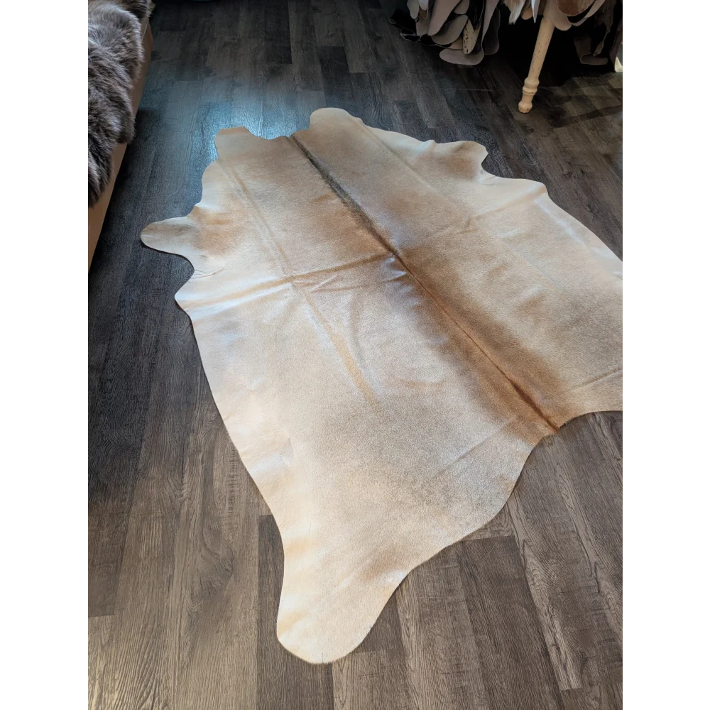 Cream-colored large cowhide rug with natural edges and subtle brown patches perfect for beautiful rugs displays