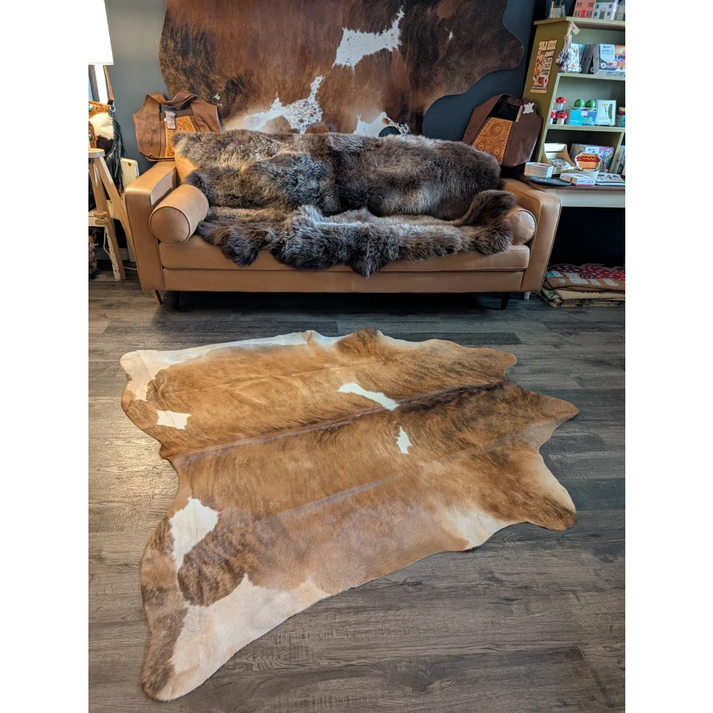 Large brown and white cowhide rug with natural fur texture perfect for beautiful rugs and home decor use