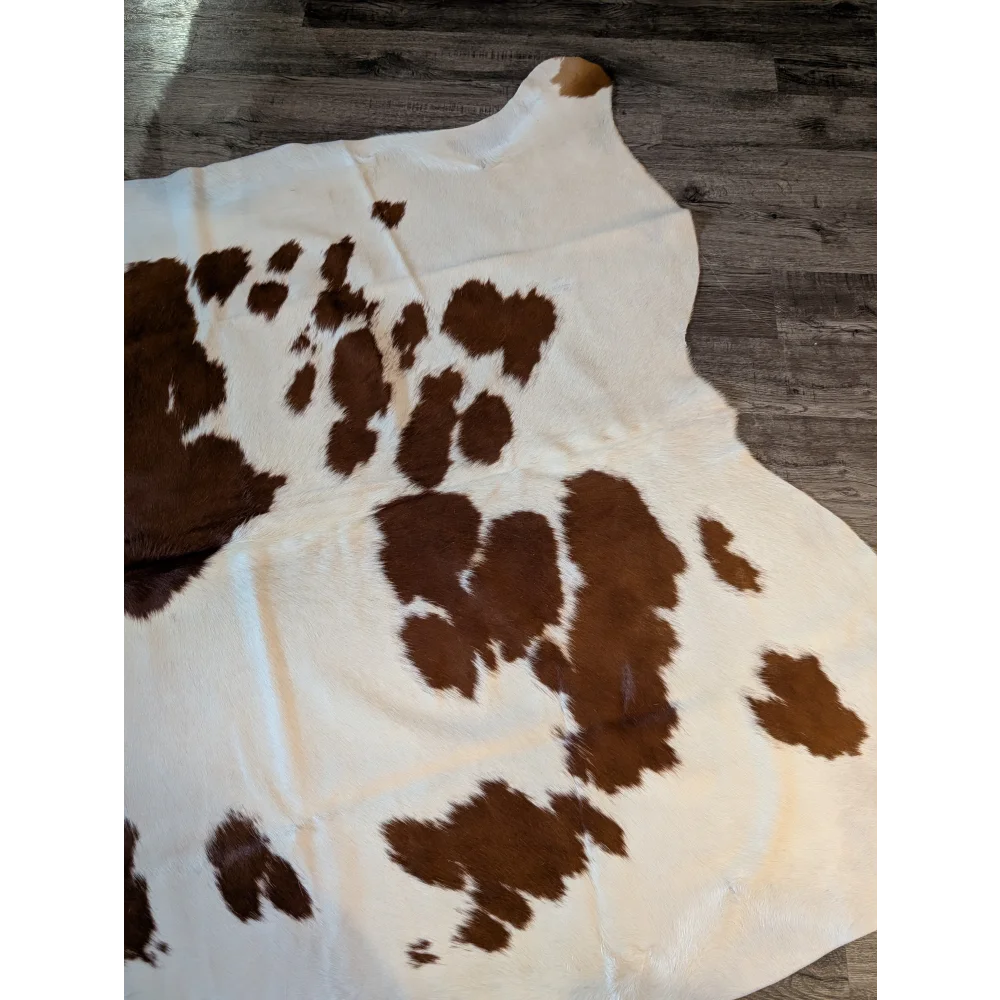 Brown and white large cowhide rug with natural fur texture showcasing unique characteristics measuring 81 by 68 inches