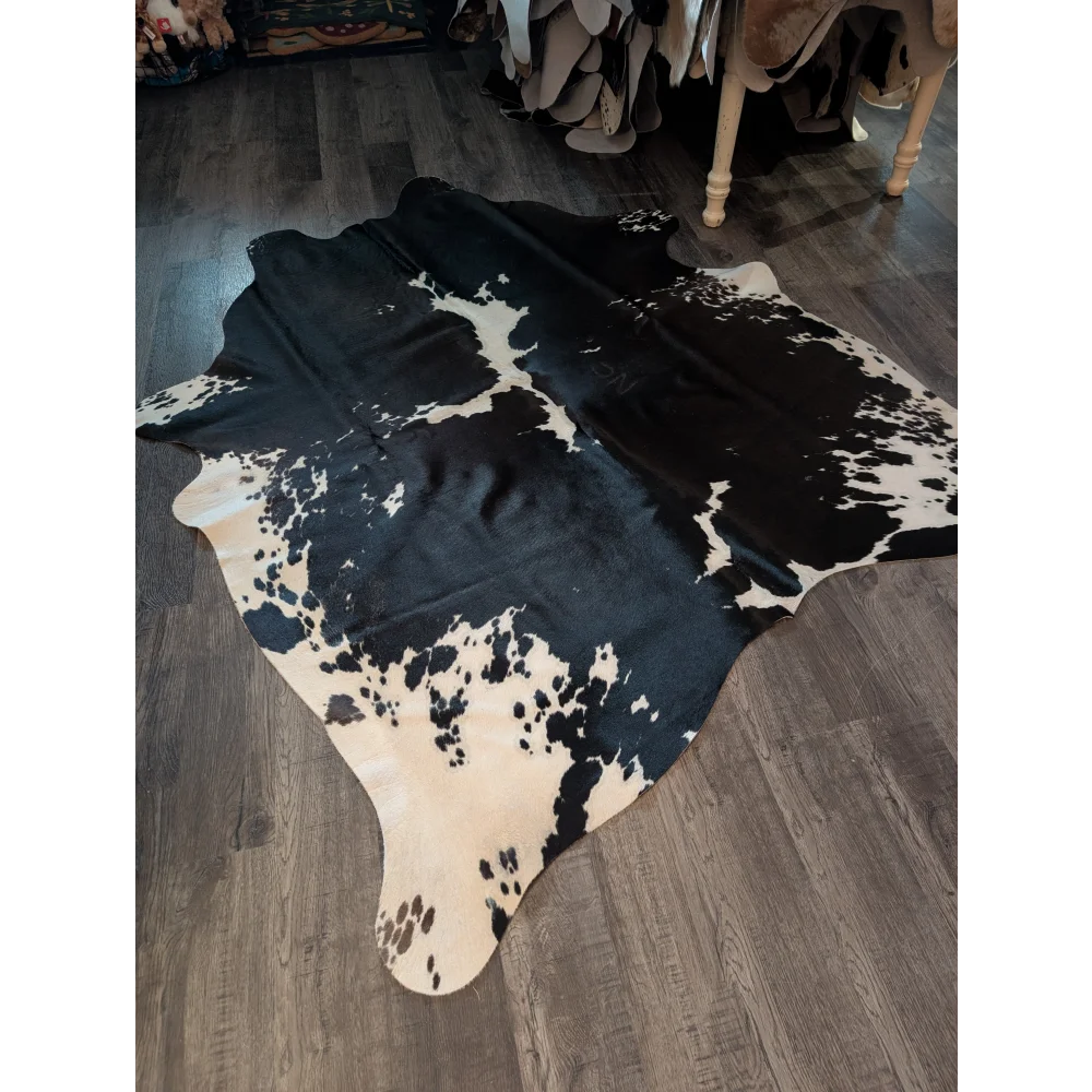 Large black and white cowhide rug with natural irregular fur patches perfect for beautiful rugs collection