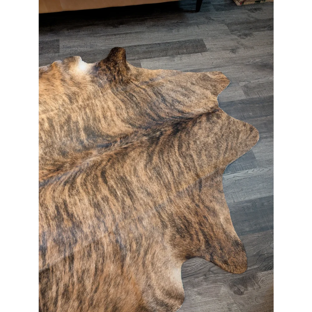Large cowhide rug in brown and black brindle with natural fur texture showcasing unique characteristics