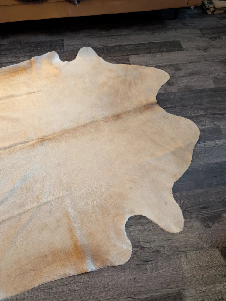 Natural tan large cowhide rug with soft textured surface and unique irregular edges perfect for any room