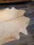 Natural tan large cowhide rug with soft textured surface and unique irregular edges perfect for any room