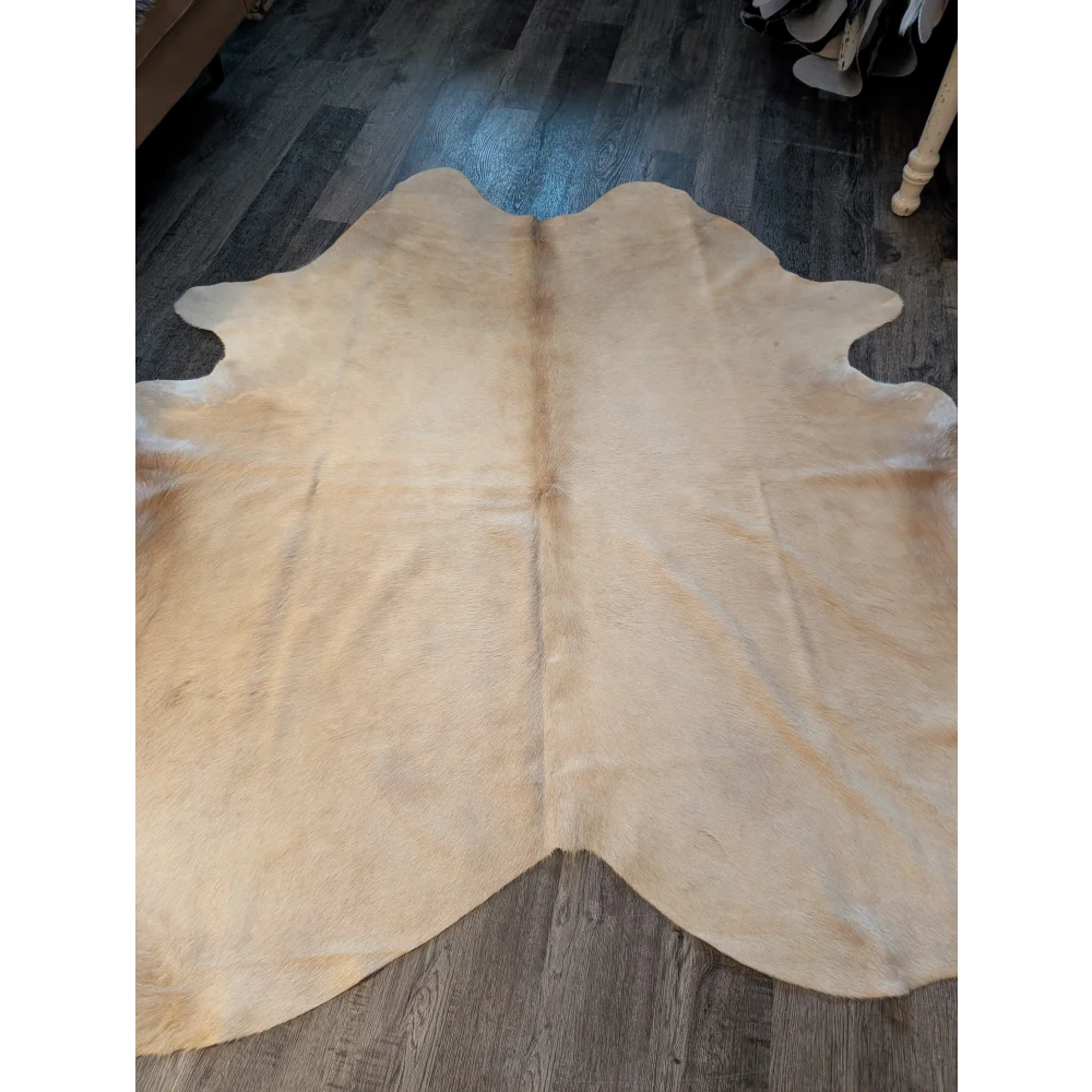 Beige large cowhide rug with natural fur texture and unique irregular edges perfect for stylish decor