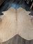 Beige large cowhide rug with natural fur texture and unique irregular edges perfect for stylish decor