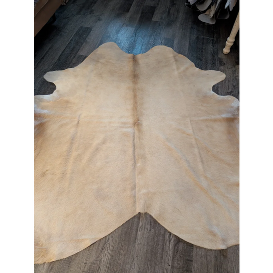 Beige large cowhide rug with natural fur texture and unique irregular edges perfect for stylish decor