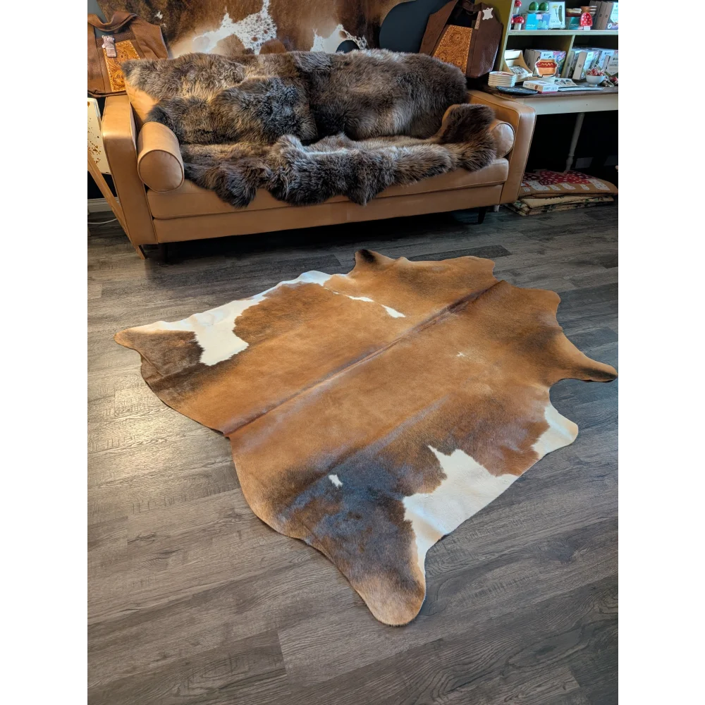 Gorgeous large cowhide rug in brown and white with natural irregular edges and unique characteristics