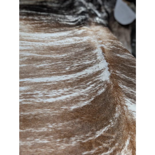 Stunning extra large cowhide rug in brown and white fur with textured pattern