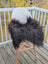 Black icelandic sheepskin chair draped over modern white chair with wooden legs from extra large chair pads collection