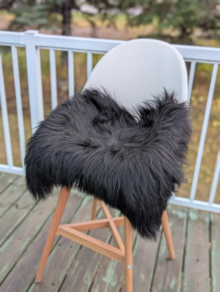 Black icelandic sheepskin chair cover with fluffy faux fur texture perfect for extra large sheepskin chair squares