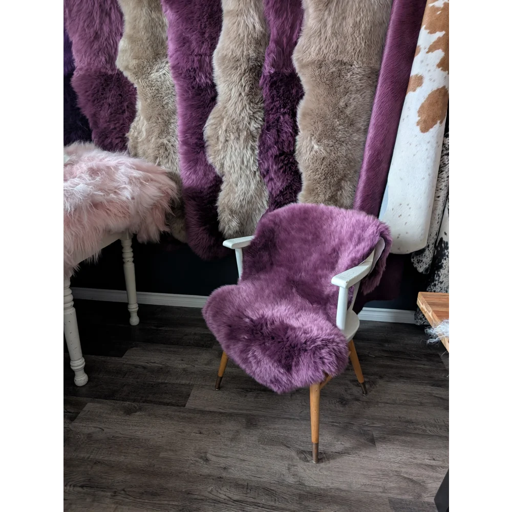 Lavender merino sheepskin chair with white arms, wood legs