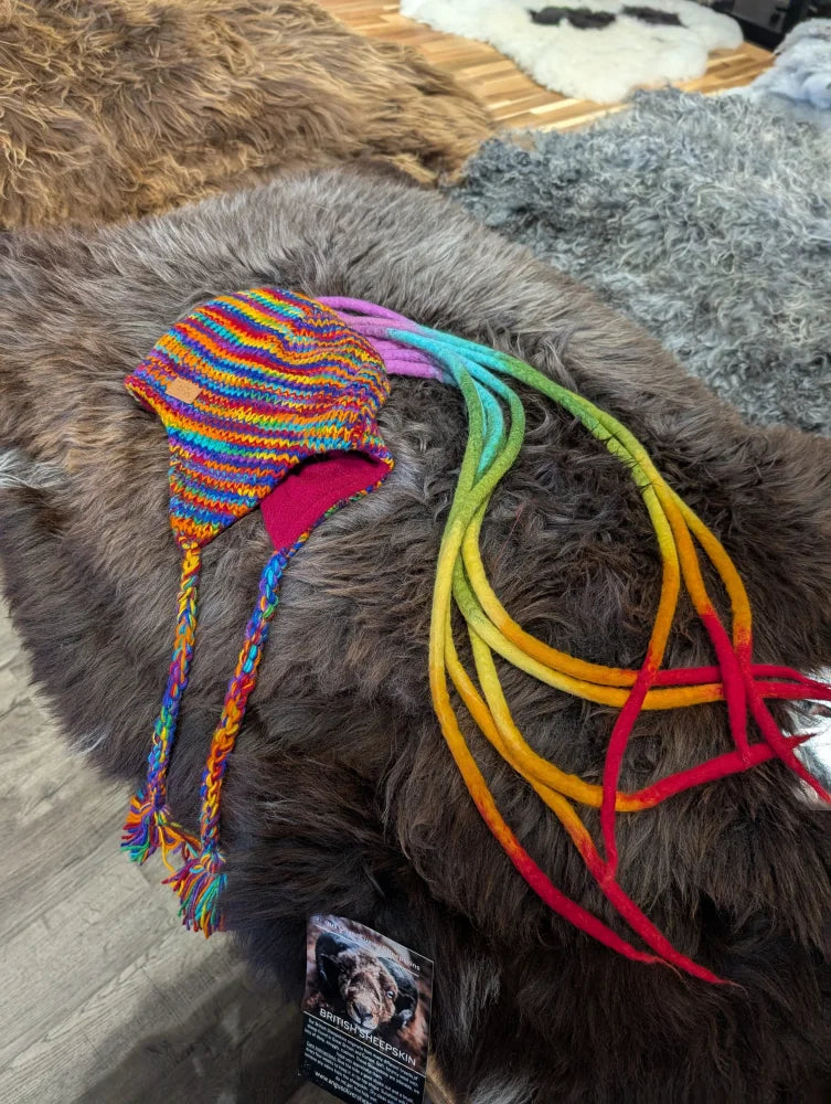 Colorful knitted rainbow Rasta hat with earflaps and rainbow braided ties
