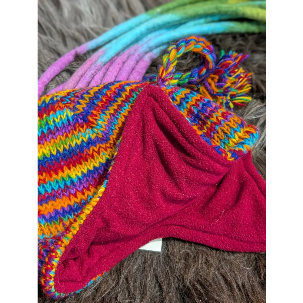 Rainbow rasta hat with colorful stripes, red fleece lining, and pom-pom for winter warmth