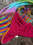 Rainbow rasta hat with colorful stripes, red fleece lining, and pom-pom for winter warmth