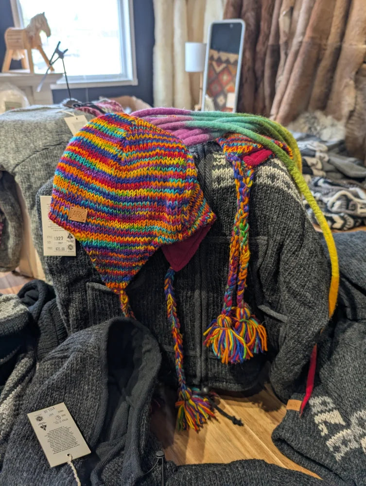 Colorful rainbow Rasta hat with ear flaps and braided ties, perfect as a rasta hat
