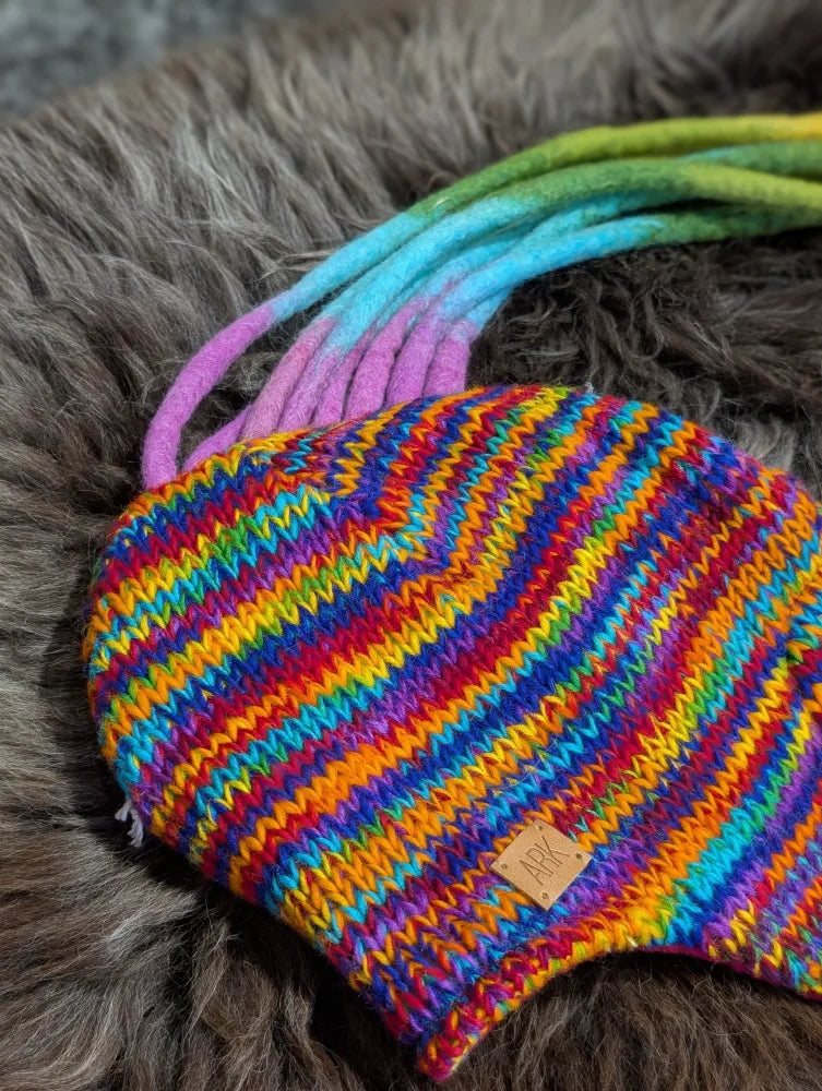 Colorful rainbow rasta hat with knit stripes and dreadlock tassels for a cool look