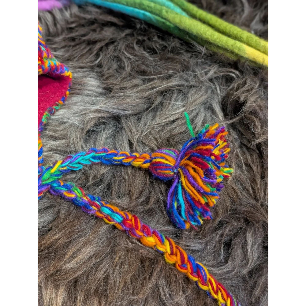 Colorful braided yarn tassel and cord on a Rainbow Rasta Hat for a fun look
