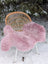 A soft fluffy pink merino sheepskin throw draped over a wicker chair perfect for cozy decor and reach standards