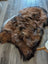 A plush irregular icelandic sheepskin rug in natural dark rusty brown black and white wool icelandic fur measuring 57 by 38 inches