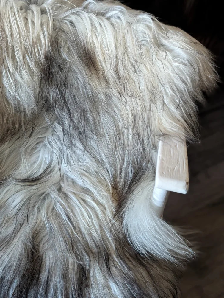 A plush long wool icelandic faux fur throw in cream and dark gray tones perfect for cozy decor