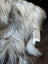 A plush long wool icelandic faux fur throw in cream and dark gray tones perfect for cozy decor