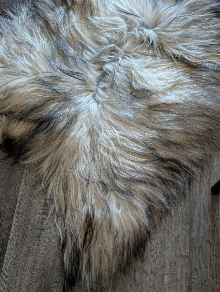 A plush fall 2 58 x 30 faux fur rug in cream and dark brown strands on wood floor long wool icelandic sheepskins