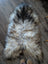 A plush long wool icelandic sheepskin rug in natural grey white and black on a wooden floor for cozy decor