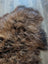 A plush naturally textured icelandic sheepskin rug in dark rusty brown tones perfect for cozy wool icelandic decor