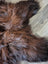 A plush shaggy brown wool icelandic sheepskin rug with natural color variations and soft textured surface