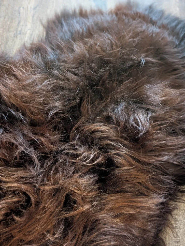 A massive soft shaggy brown icelandic sheepskin rug with natural color variations and wool icelandic texture